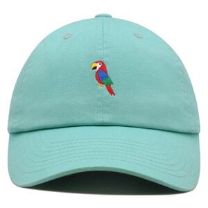 May include: A turquoise blue baseball cap with an embroidered parrot design. The parrot is red, green, blue, and yellow.
