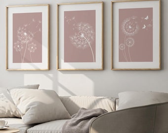 Puede incluir: Tres impresiones enmarcadas con un fondo rosa pálido e ilustraciones de dientes de león blancos. Las impresiones están dispuestas en una fila en una pared blanca.
