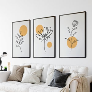May include: Three minimalist line art prints with black outlines of stylized flowers and leaves on a white background. Each print features a yellow circle with a white outline.
