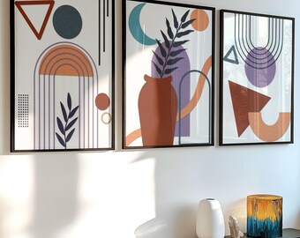 Puede incluir: Tres impresiones de arte abstracto enmarcadas con formas geométricas y elementos orgánicos en tonos de marrón, naranja, morado, azul y verde. Las impresiones están colgadas en una pared blanca.