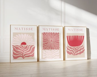 May include: Three framed prints with the word "MATISSE" at the top of each. The prints feature abstract floral designs in shades of pink and red.