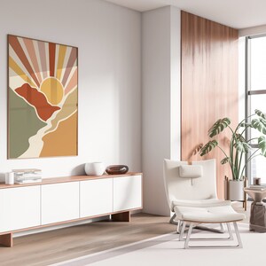 May include: A white armchair with a footstool sits in a living room with a large window, a wooden cabinet, and a colourful abstract print on the wall. A potted plant is in the corner.