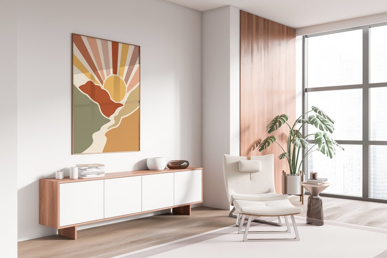 May include: A white armchair with a footstool sits in a living room with a large window, a wooden cabinet, and a colourful abstract print on the wall. A potted plant is in the corner.