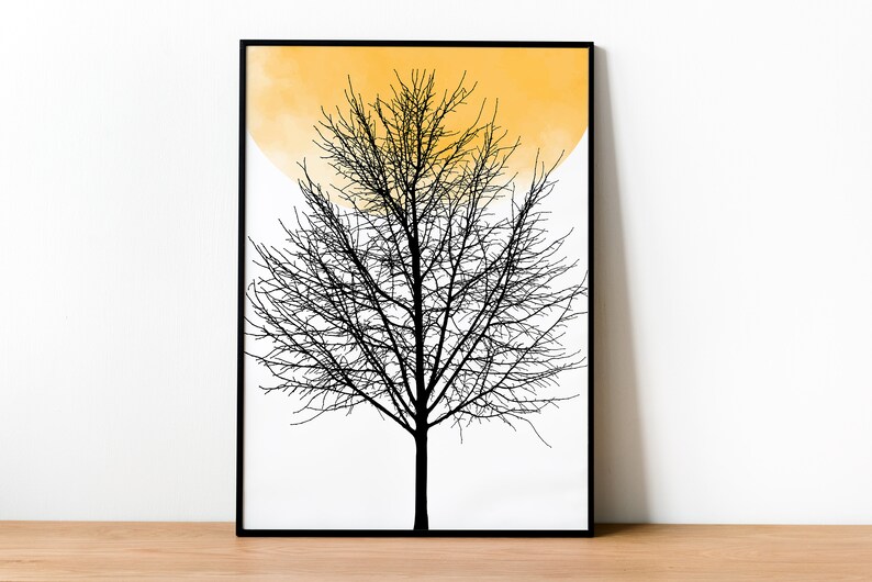 May include: A black and white print of a bare tree with a yellow watercolor circle behind it. The print is framed in a black frame.