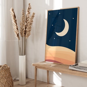 以下が含まれることがあります： 濃い青色の背景に三日月と星が描かれた額装されたプリント。オレンジ、イエロー、レッドのグラデーションで重ねられた夕焼けが描かれている。