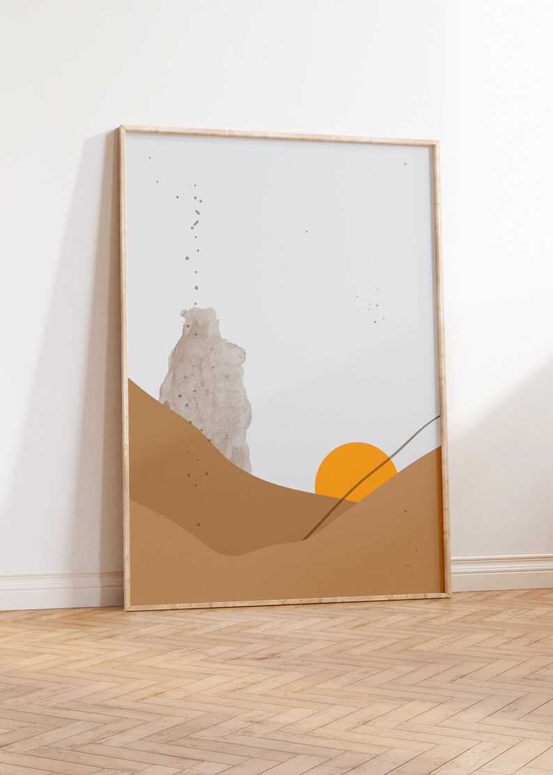 May include: A framed abstract art print with a beige, brown, and orange color scheme. The print features a stylized landscape with a sun setting over hills.