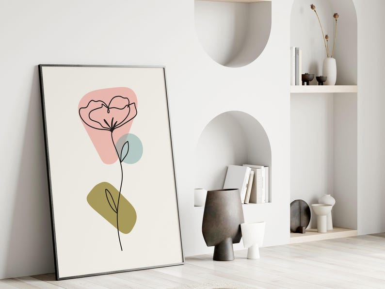 May include: A black framed print with a minimalist line drawing of a flower with pink, green, and blue abstract shapes.