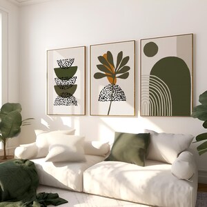May include: Three abstract art prints with a green, brown, and white color scheme. The prints feature geometric shapes, a stylized plant, and a curved line design.