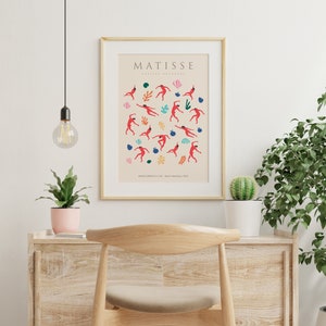 Puede incluir: Un p&oacute;ster con fondo beige que presenta una ilustraci&oacute;n colorida de bailarines y flores. El texto "MATISSE" y "PAPIERS DECOUPES" est&aacute; en la parte superior del p&oacute;ster. El texto "LE CARNAVAL" est&aacute; en la parte inferior del p&oacute;ster.