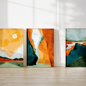 May include: Three abstract landscape paintings in gold frames. The paintings feature a variety of colors, including yellow, orange, blue, and green. The paintings are hung on a white wall.