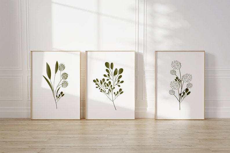 Set of three minimalist botanical posters featuring green leaves and stems in simple Scandinavian design on white background.