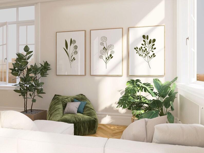 Set of three minimalist botanical posters featuring green leaves and stems in simple Scandinavian design on white background.