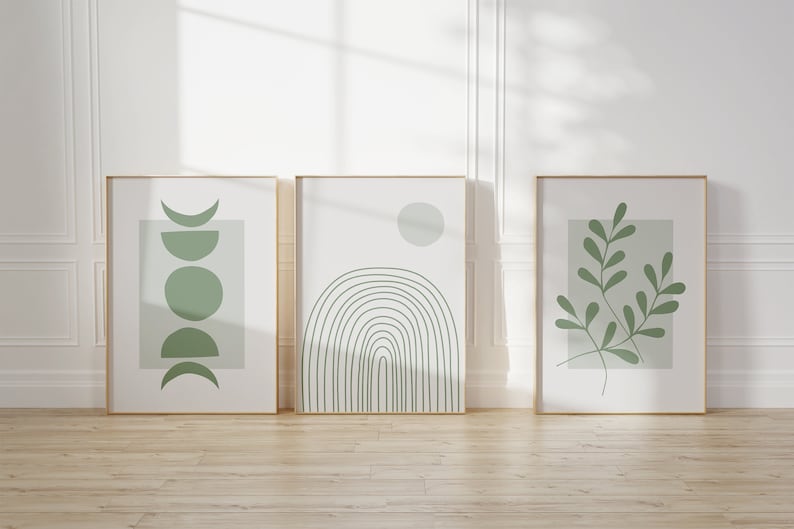 Pu&ograve; includere: Tre stampe incorniciate con disegni astratti minimalisti in tonalit&agrave; di verde. Le stampe presentano un design a mezzaluna, un arcobaleno e un ramo frondoso.