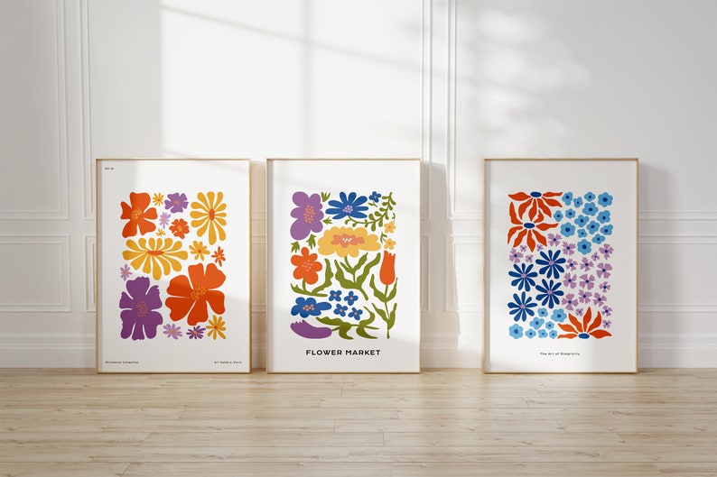 K&ouml;nnte beinhalten: Drei gerahmte Drucke mit bunten Blumenmustern. Die Drucke sind betitelt mit "Morning Dewdrops", "Flower Market" und "The Art of Blooming".