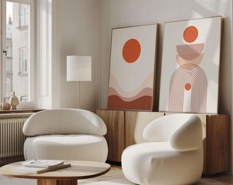 Puede incluir: Un salón moderno con dos impresiones artísticas abstractas con diseños geométricos en naranja y rosa. Dos sillones blancos y una mesa de centro de madera frente a una ventana. Un mueble de madera y una lámpara de pie completan la decoración.
