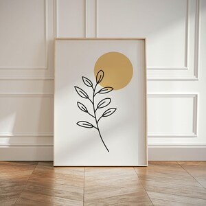 May include: A framed print with a minimalist design featuring a black line drawing of a branch with leaves and a yellow circle.