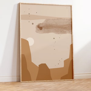 May include: A framed abstract print with a beige background and brown shapes. The print features a large brown cloud shape in the center and smaller brown circles scattered throughout. The print is framed in a light wood frame.