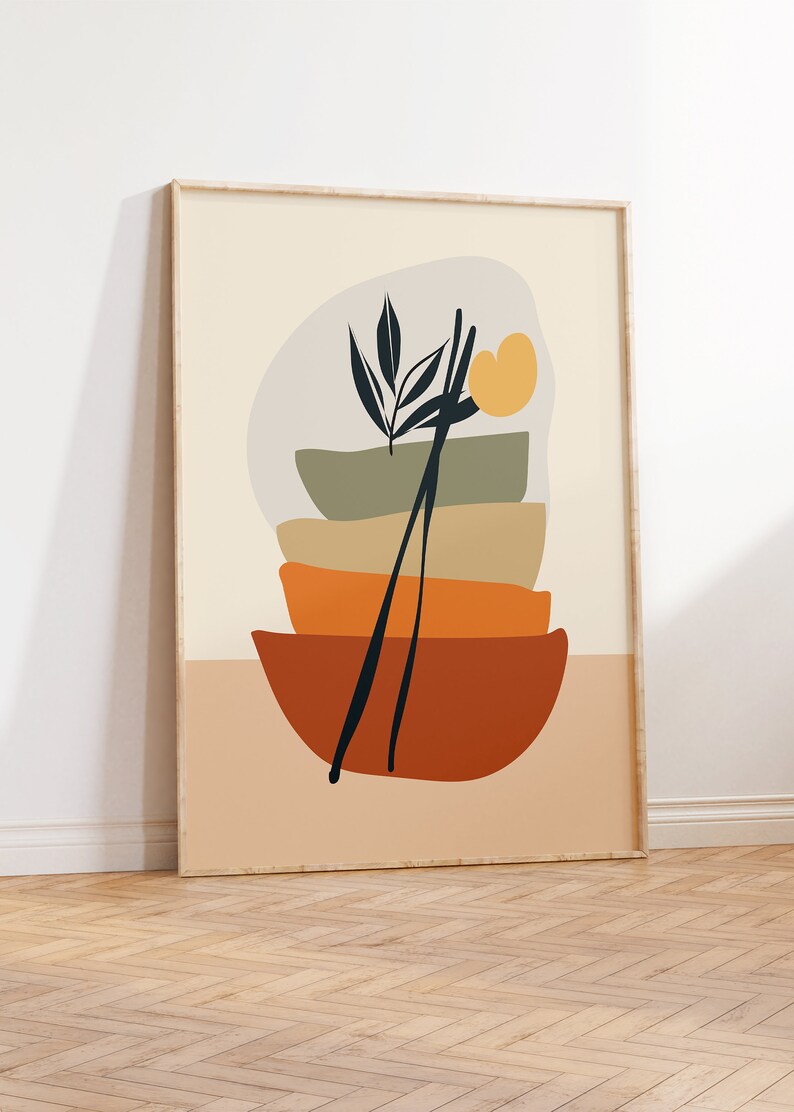 May include: Abstract art print featuring a stack of four bowls in shades of green, orange, and brown, with a black silhouette of a plant and chopsticks in the centre. The background is a light beige colour.