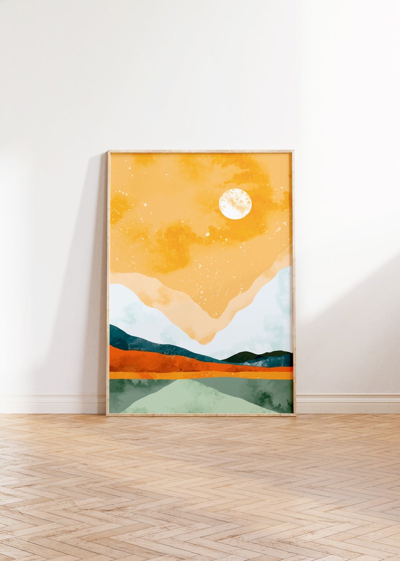 May include: A framed abstract landscape painting with a yellow, orange, and green color scheme. The painting depicts a mountain range with a large white circle in the sky.