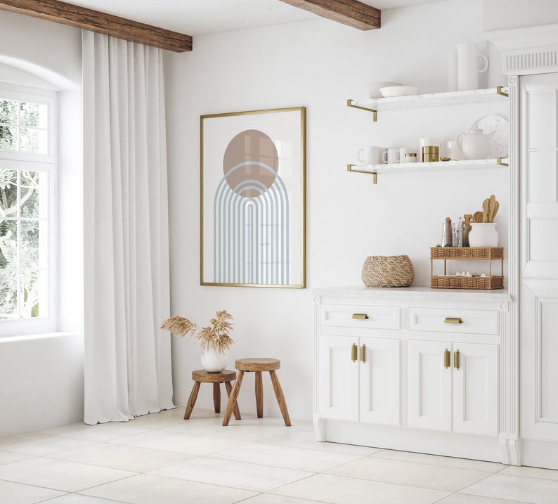 May include: A white kitchen cabinet with two drawers and four doors. The cabinet has gold hardware and a white marble countertop. There are two shelves above the cabinet with gold brackets. The shelves are decorated with a wicker basket, a vase with dried flowers, and other decorative items.