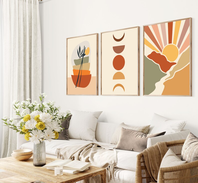 May include: Three abstract art prints in a minimalist style. The first print features a stack of bowls with a plant and chopsticks. The second print features a series of circles in shades of orange and brown. The third print features a stylised sunset with a mountain range in shades of green, orange, and brown.