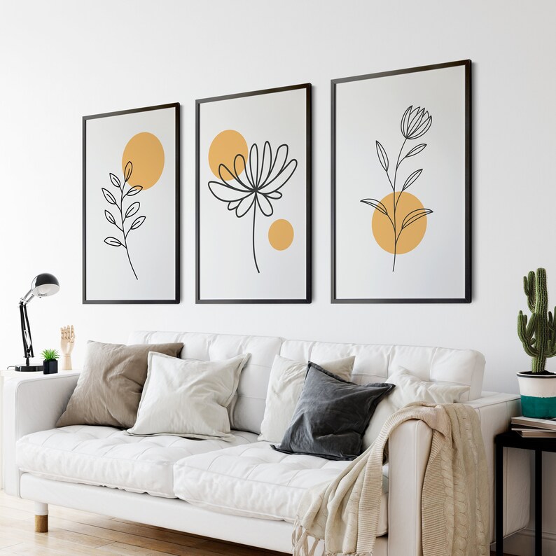 May include: Three minimalist line art prints with black outlines of stylized flowers and leaves on a white background. Each print features a yellow circle with a white outline.