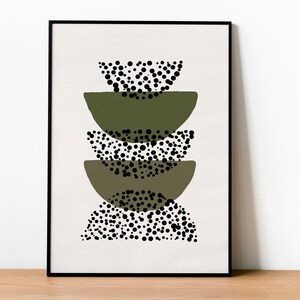 May include: A framed print with an abstract design featuring stacked green semi-circles with black polka dots.