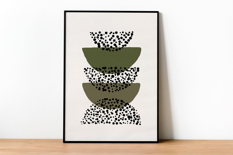 May include: A framed print with an abstract design featuring stacked green semi-circles with black polka dots.