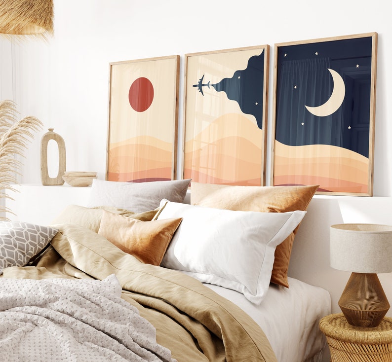 Set of three minimalist desert posters featuring abstract sand dunes, red sun, airplane in the sky, and moon with stars. Modern boho wall art in warm beige and navy tones.