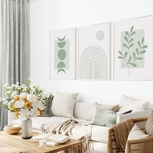 Pu&ograve; includere: Tre stampe d'arte minimaliste con sfondo bianco e disegni astratti verdi. Le stampe presentano un design a mezzaluna e cerchio, un arcobaleno e un ramo frondoso.
