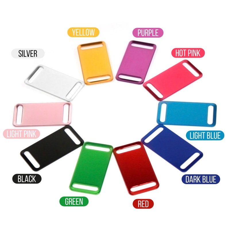 May include: Assortment of 12 colorful metal dog ID tags. The tags are rectangular with rounded corners and have a hole for attaching to a collar. The colors include silver, light pink, black, green, red, dark blue, light blue, hot pink, purple, and yellow.