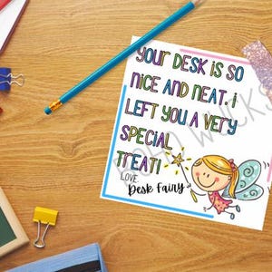 May include: A colorful desk scene with a note that reads "Your desk is so nice and neat. I left you a very special treat! Love, Desk Fairy." Includes a pencil, binder clips, and a small chalkboard.