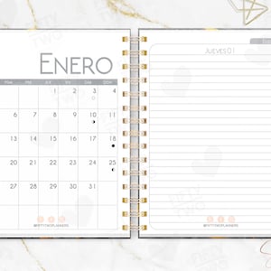 Peut inclure: Agenda ouvert avec un calendrier de janvier. La page de gauche affiche un calendrier avec les jours et les dates. La page de droite est lignée pour les notes. Un crayon rose est posé à droite.