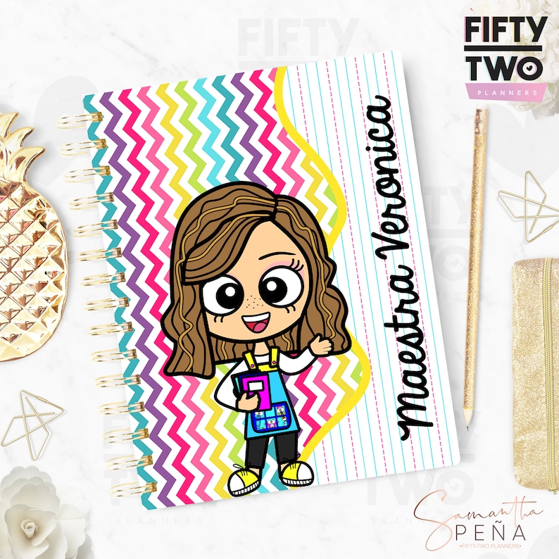 May include: Spiral-bound planner with a cartoon illustration of a teacher holding a book. The cover features a colorful zigzag pattern and the text "Maestra Veronica". The planner has a gold spiral binding.