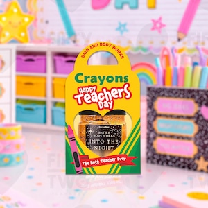 Puede incluir: Una caja de regalo amarilla con forma de crayón con el texto "Happy Teacher's Day" y "The Best Teacher Ever". En el interior hay un PocketBac de Bath & Body Works. Un crayón rosa está en el lateral. El fondo incluye útiles escolares coloridos.