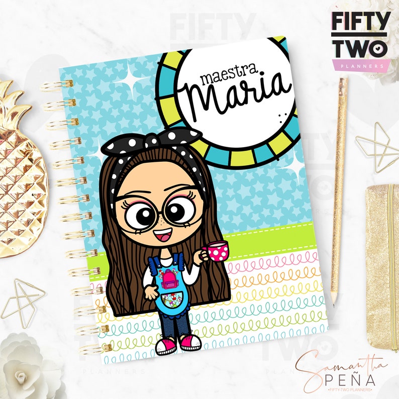 May include: Spiral-bound planner with a cartoon illustration of a woman wearing glasses and a polka-dot headband. The planner cover features the name "maestra Maria" in a circle and a light blue background with stars.