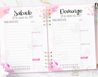 May include: A spiral-bound daily planner open to Saturday, January 2, 2027, and Sunday, January 3, 2027. The pages feature pink watercolor accents, checklists labeled Para Hacer Hoy, sections for Citas, Gastos del Día, Ingresos del Día, and a water tracker with six glass icons at the bottom.