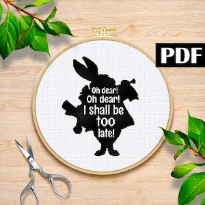 May include: Black and white cross-stitch pattern featuring the White Rabbit from Alice in Wonderland. The pattern includes the quote "Oh dear! Oh dear! I shall be too late!"