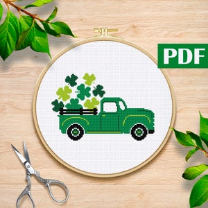 May include: A green pickup truck with a bed full of shamrock leaves. The truck is on a white background.