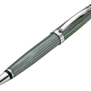 May include: A ballpoint pen featuring a sage green barrel with a fine, textured cross-hatch pattern. The pen includes polished silver-tone metal accents, a smooth conical tip, a black ring near the point, and a curved silver pocket clip.