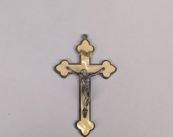 Crucifijo bañado en plata con respaldo de celuloide para realzar la figura de Jesús en la cruz.