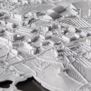 K&ouml;nnte beinhalten: Ein wei&szlig;es 3D-gedrucktes Modell einer Stadtlandschaft. Das Modell zeigt Geb&auml;ude, Stra&szlig;en und andere Details. Das Modell besteht aus glattem, wei&szlig;em Kunststoff.