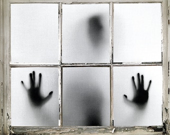 May include: A shadowy figure with outstretched hands appears trapped behind a window with a weathered white frame.