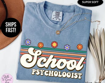 May include: A blue jean t-shirt with a retro rainbow design and the text "School Psychologist".