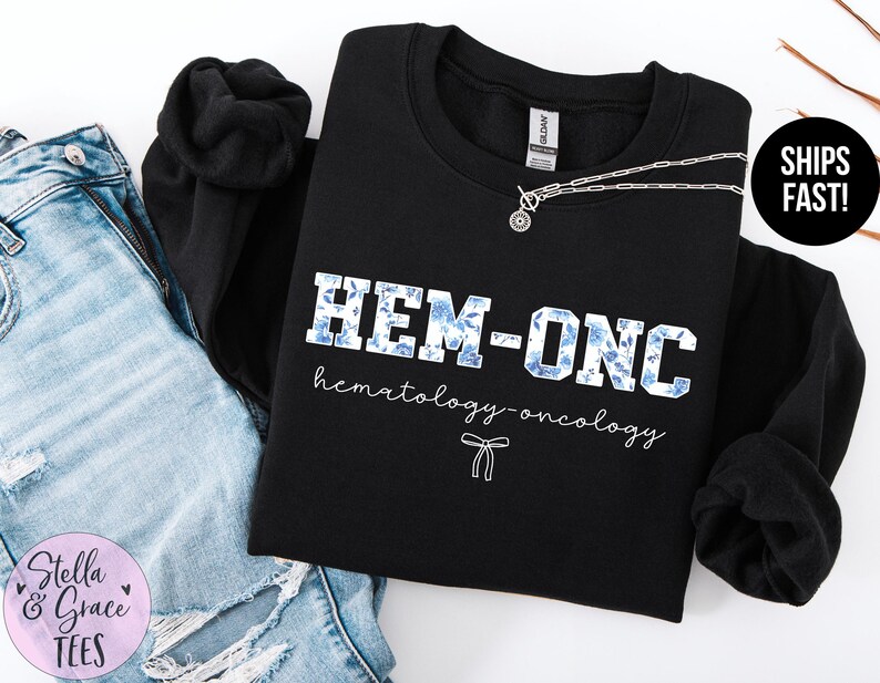 May include: Black sweatshirt with the text "HEM-ONC hematology-oncology" in white with blue floral accents.