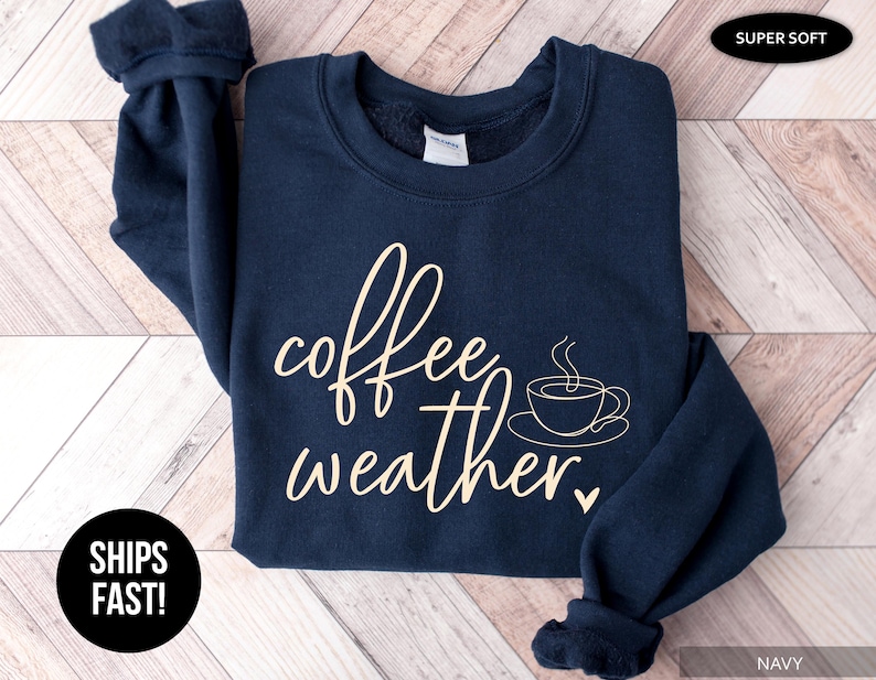 May include: Navy blue sweatshirt with the words "coffee weather" in a cursive font, along with a coffee cup graphic. The sweatshirt is labeled "super soft" and "navy".
