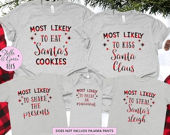 May include: A collection of five light gray t-shirts and a baby bodysuit featuring red and black plaid text. The shirts display phrases including Most Likely To Eat Santa's Cookies, To Kiss Santa Claus, To Shake The Presents, To Break An Ornament, and To Steal Santa's Sleigh, accented with small red star graphics.