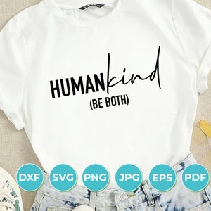May include: White t-shirt with black text that reads "HUMANkind (BE BOTH)". The shirt is laying on a light brown surface with a pair of jeans and sunglasses.