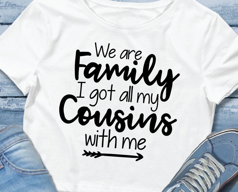 K&ouml;nnte beinhalten: Wei&szlig;es T-Shirt mit schwarzem Text, der "We are family I got all my cousins with me" lautet und einem Pfeil, der nach rechts zeigt.