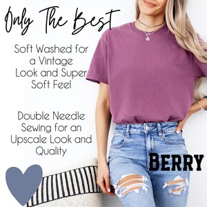 K&ouml;nnte beinhalten: Eine Frau tr&auml;gt ein mauvefarbenes T-Shirt mit dem Text "Only The Best" und "Soft Washed for a Vintage Look and Super Soft Feel" und "Double Needle Sewing for an Upscale Look and Quality" &uuml;ber dem Text "BERRY" auf einer hellblauen Jeans.